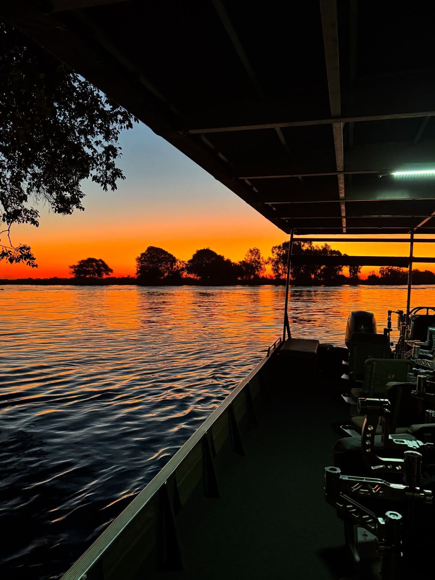 Chobe River sunset scene with a safari boat in Botswana.